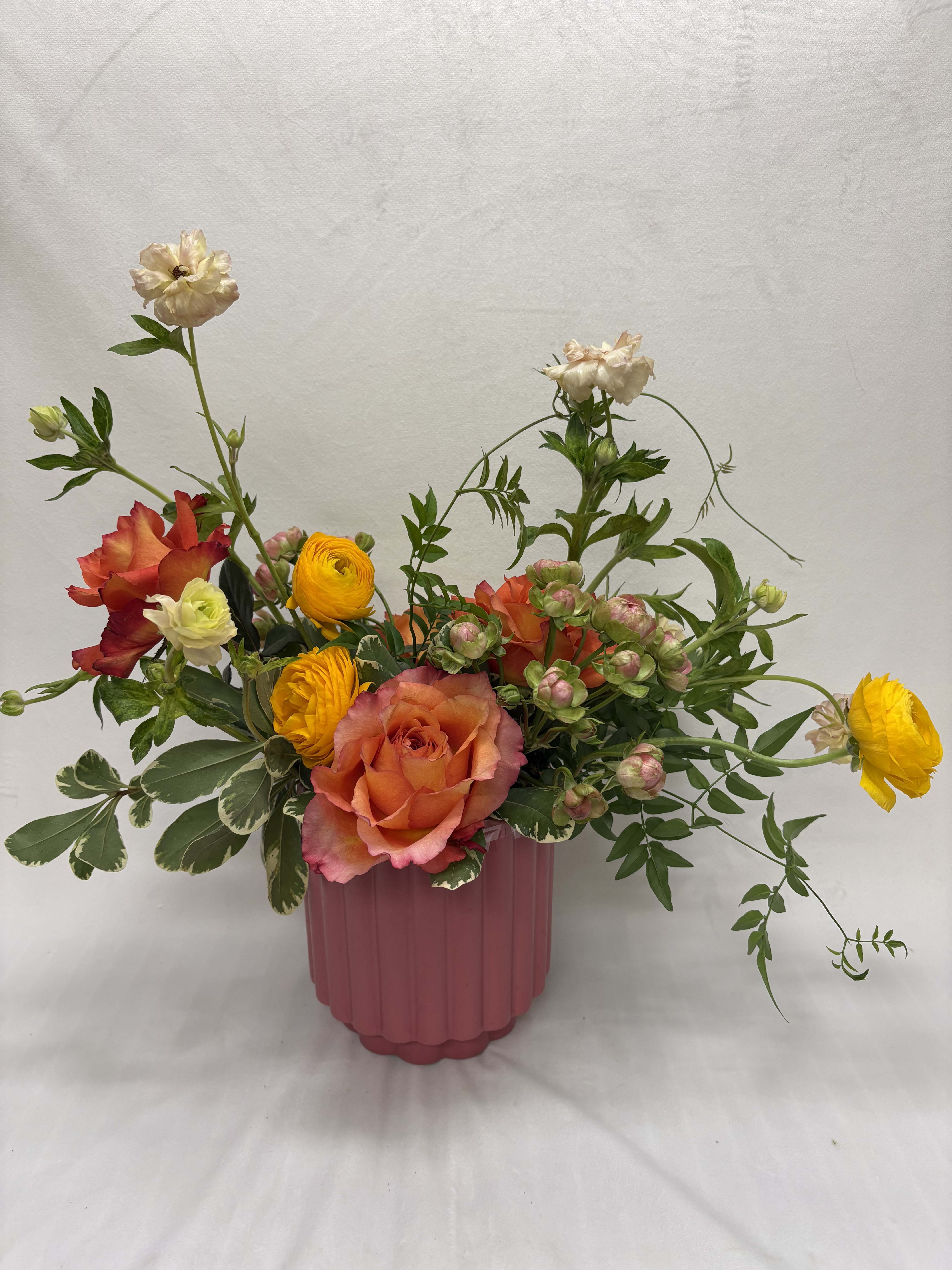 Mixed bouquet of roses and ranunculus in a pink vase