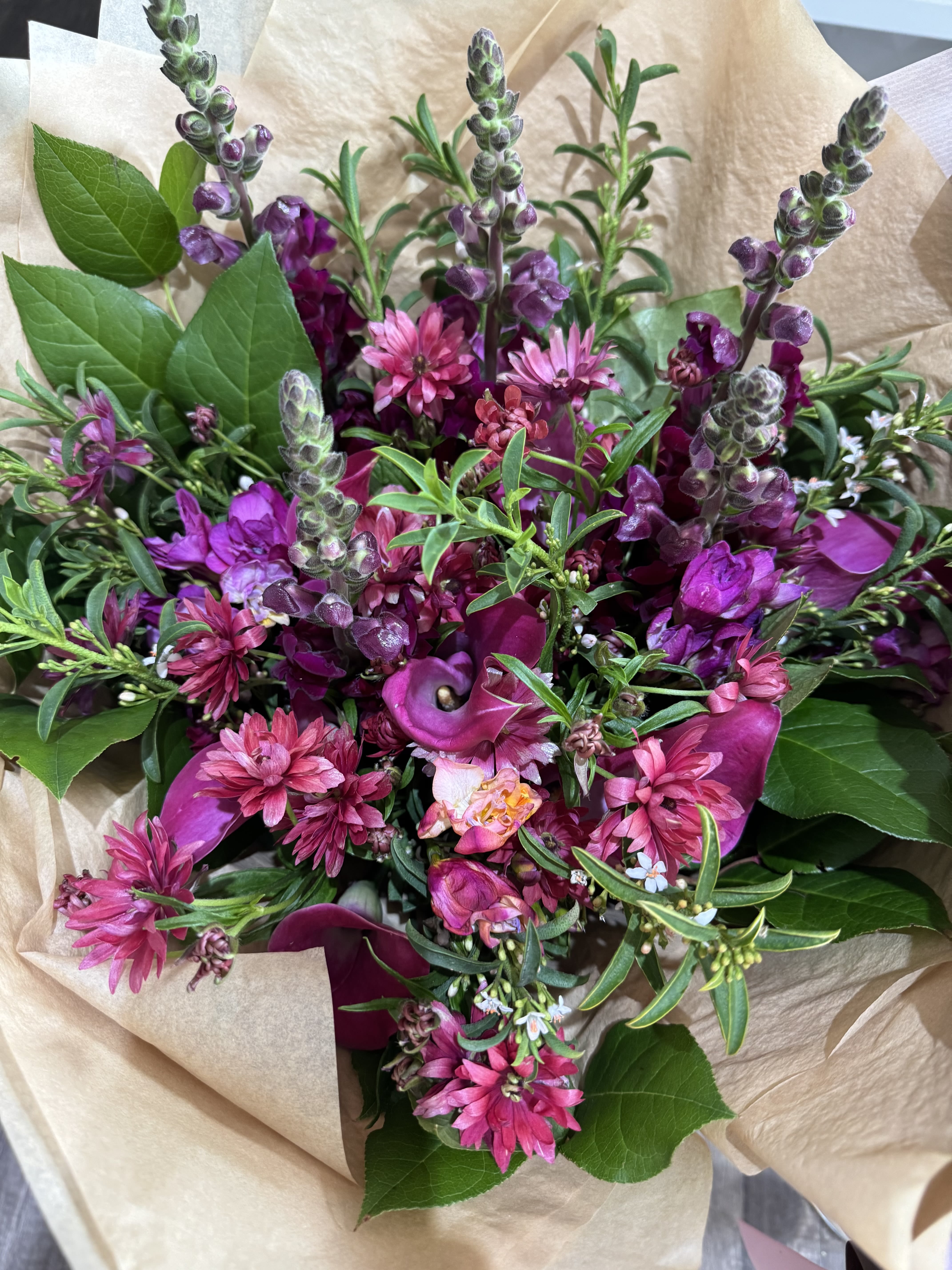 Moody Purples - This bold statement of purples and magentas will bright anybody's day.  A beatufil mix of ranunculus, snapgragons, calas, veronicas and greens.
