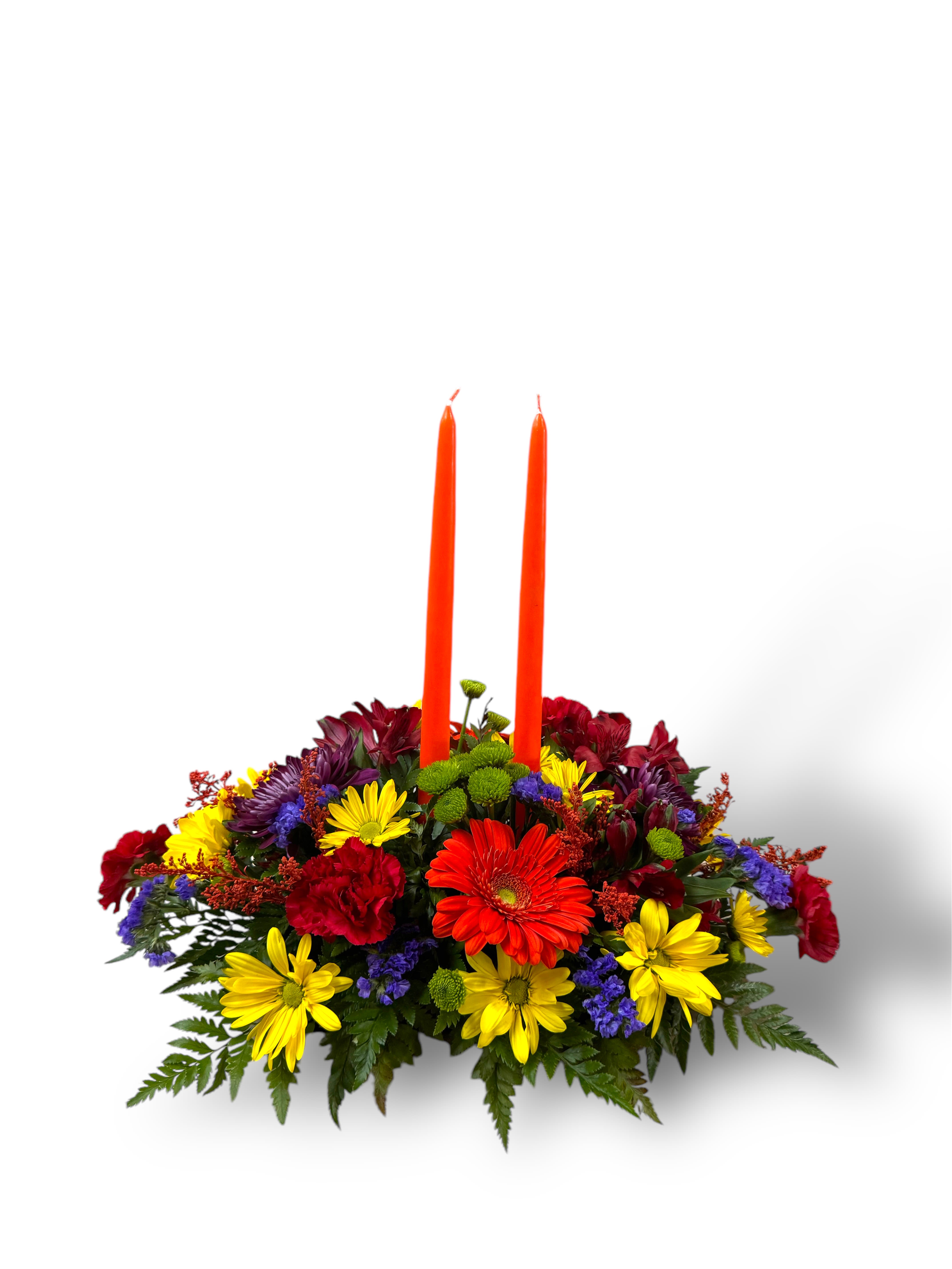 Colorful floral centerpiece with two orange taper candles