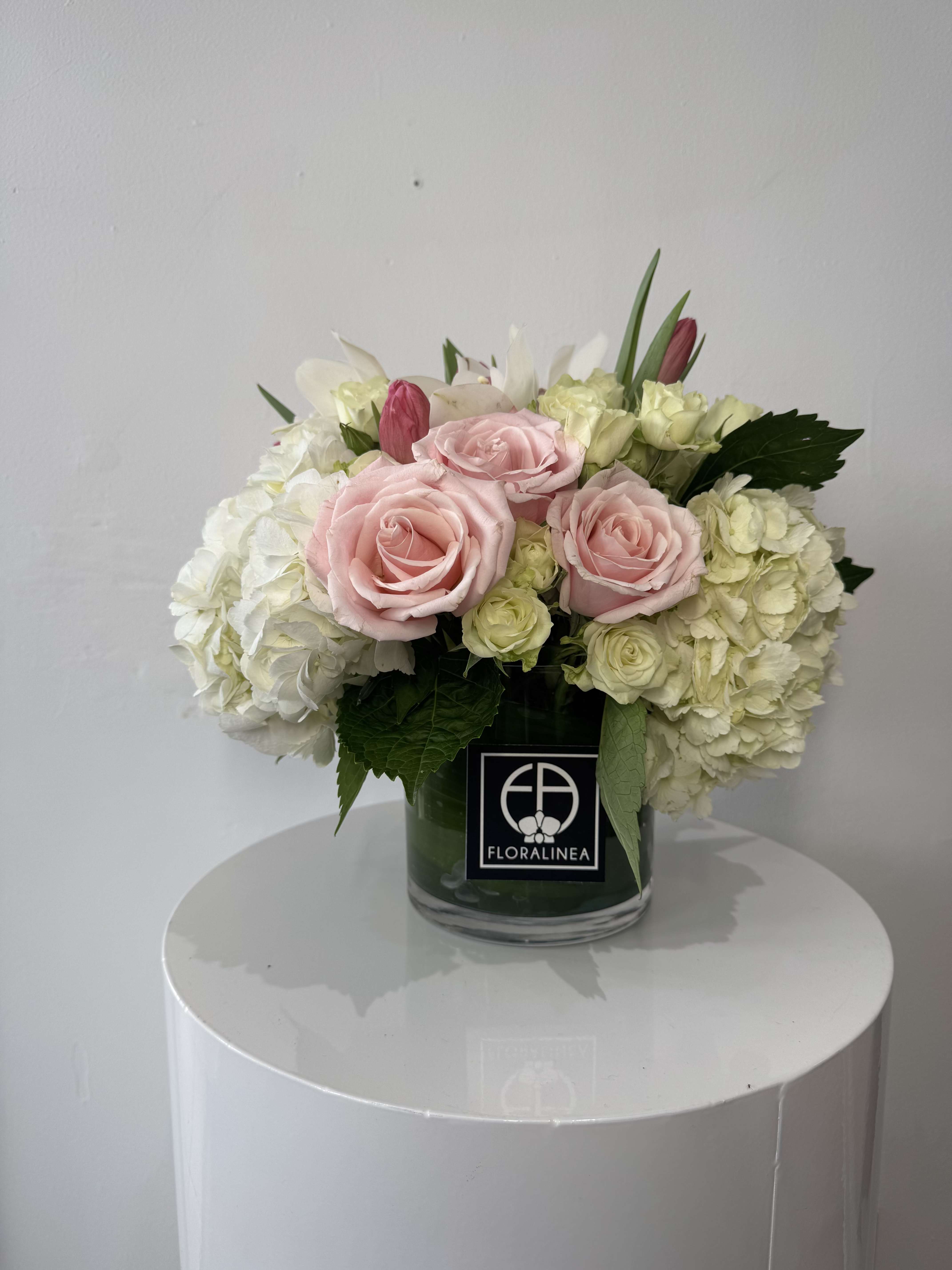 Pink roses and white hydrangeas arranged in a glass vase