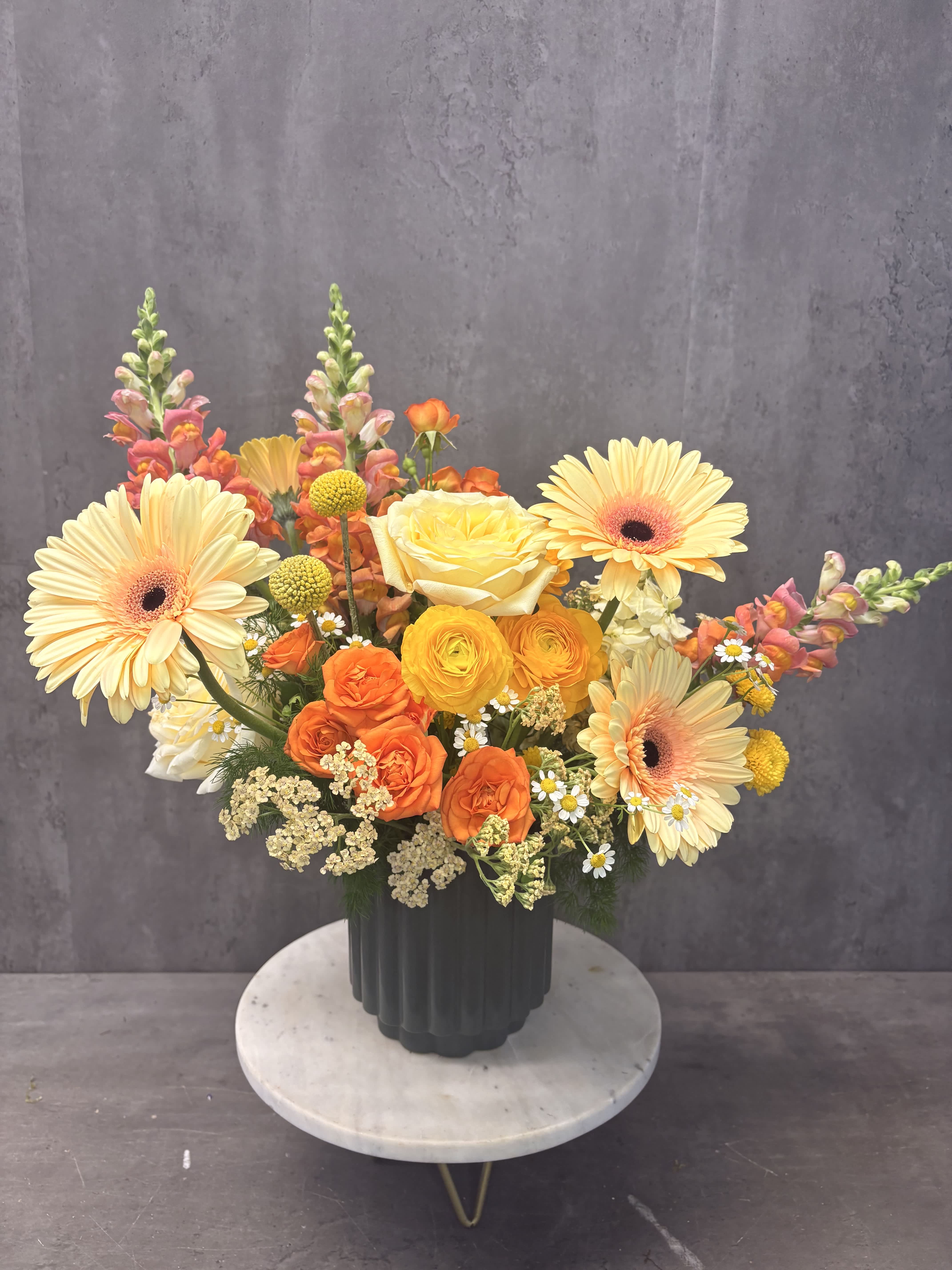 Colorful mixed bouquet in a dark vase with gerberas and roses