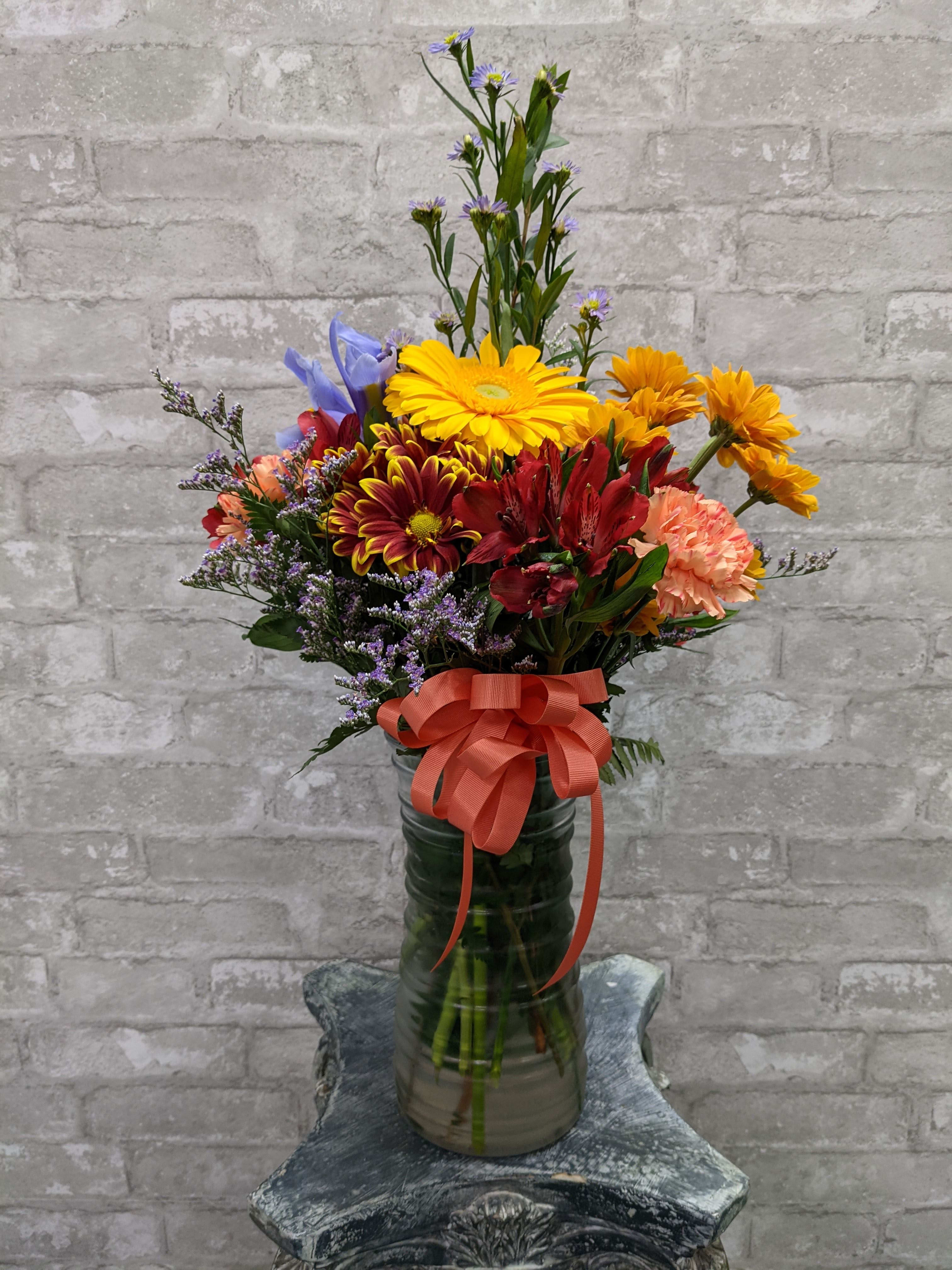 Enchanting Fall FG205F - Appealing medium floral arrangement in tall vase. Season flowers are featured with a to compliment design.  Appropriately 24" H and 15" W.