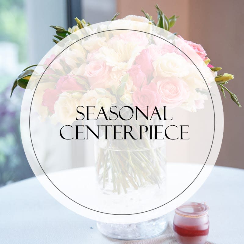 Pink and white flower centerpiece in a clear glass vase