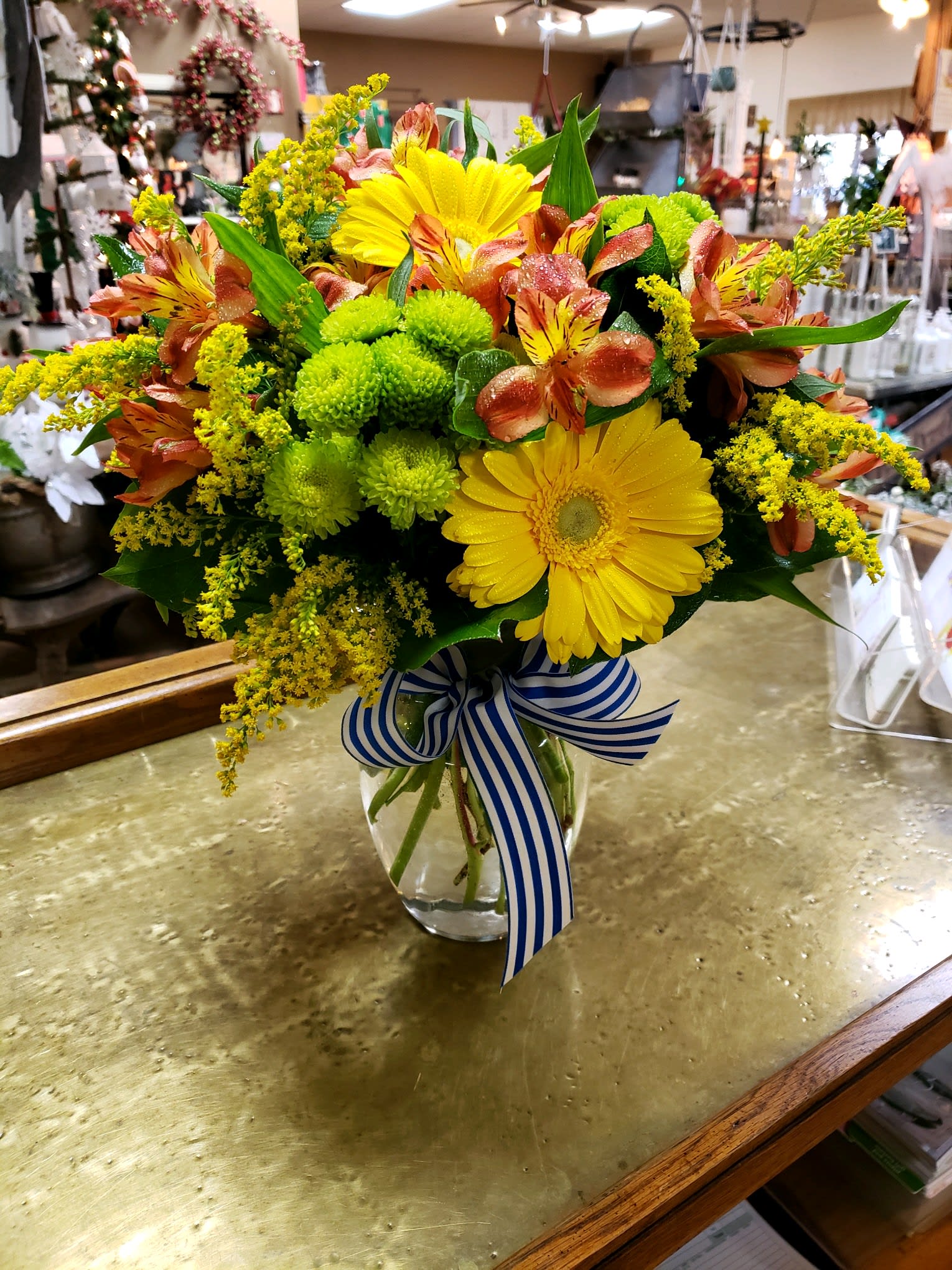 Bouquet of yellow gerbera daisies and orange alstroemeria in a glass vase