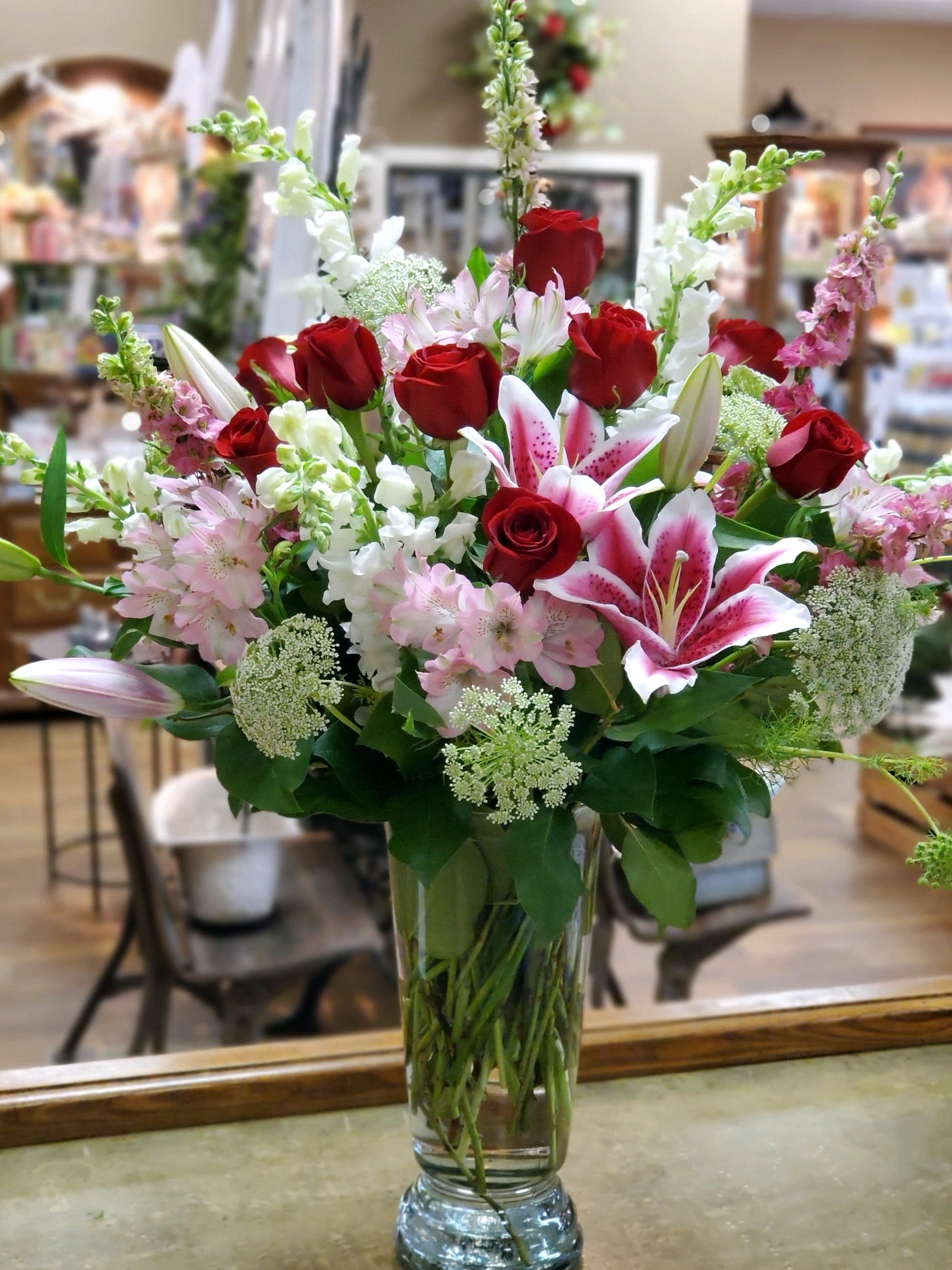Red roses and pink lilies in a clear glass vase