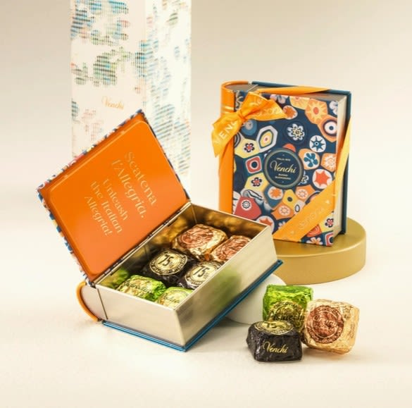 Open gift boxes of assorted chocolates with colorful wrappers