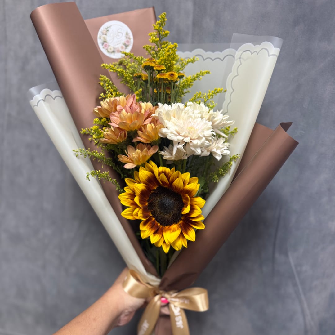 Handheld bouquet with sunflowers, white and peach chrysanthemums, and brown wrapping