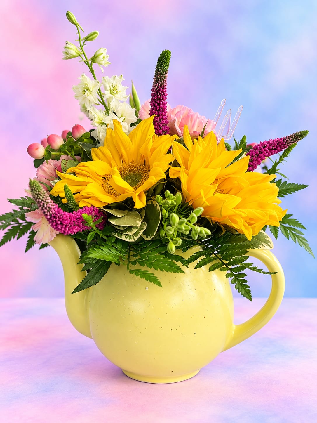Yellow sunflowers and pink flowers arranged in a yellow pitcher