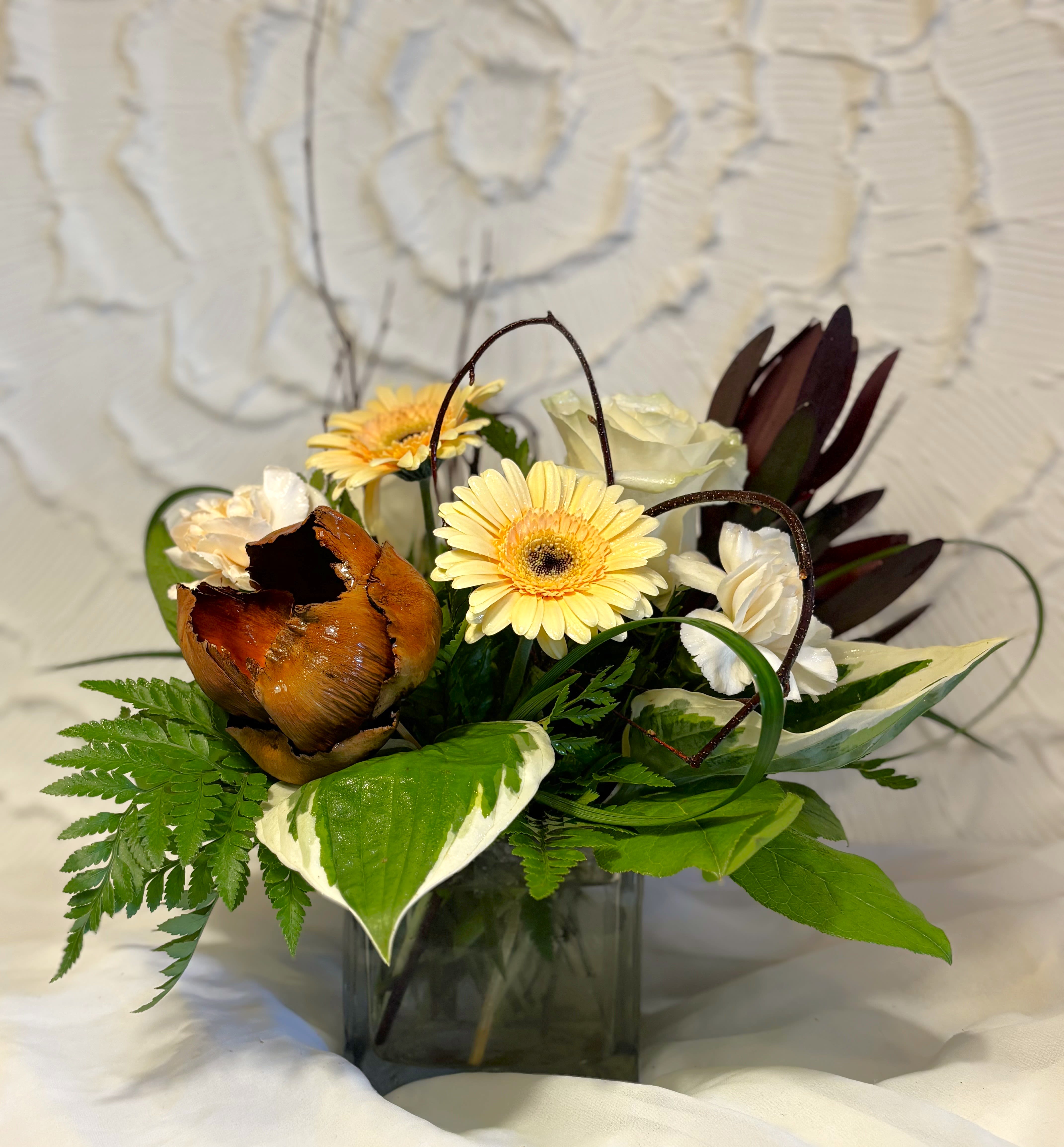 Hazelnut Autumn - This vase is made with a mixture of cream and brown flowers including, gerbera daisies, safari, roses, carnations, pods and branches. An alternative for a more neutral fall. 