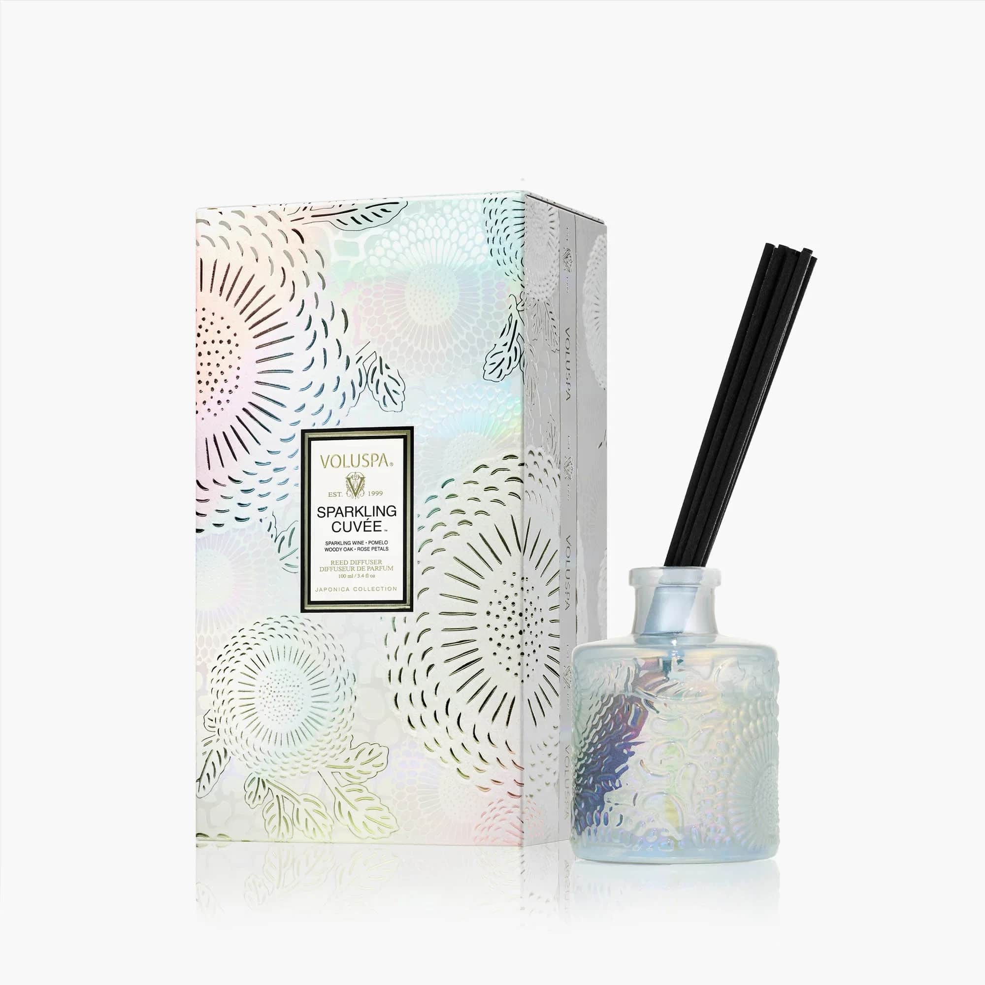 Voluspa Sparkling Cuvée Reed Diffuser - Pop a bottle of Voluspa’s finest blend, it’s time to celebrate! A mix of beautiful aromatic complexity, Sparkling Cuvée opens with vivacious fruit tones of Sparkling Wine, Pomelo and Red Currant. The effervescence of Sparkling Wine is the heart of the celebration, with bubbles cascading to the surface, dancing and mingling with juicy Nectarine and Bulgarian Rose Petals. A velvety, smooth finish of Woody Oak serves as the perfect stage for this aromatic affair. Raise a glass of Sparkling Cuvée, your olfactory aperitif for every unforgettable occasion.
