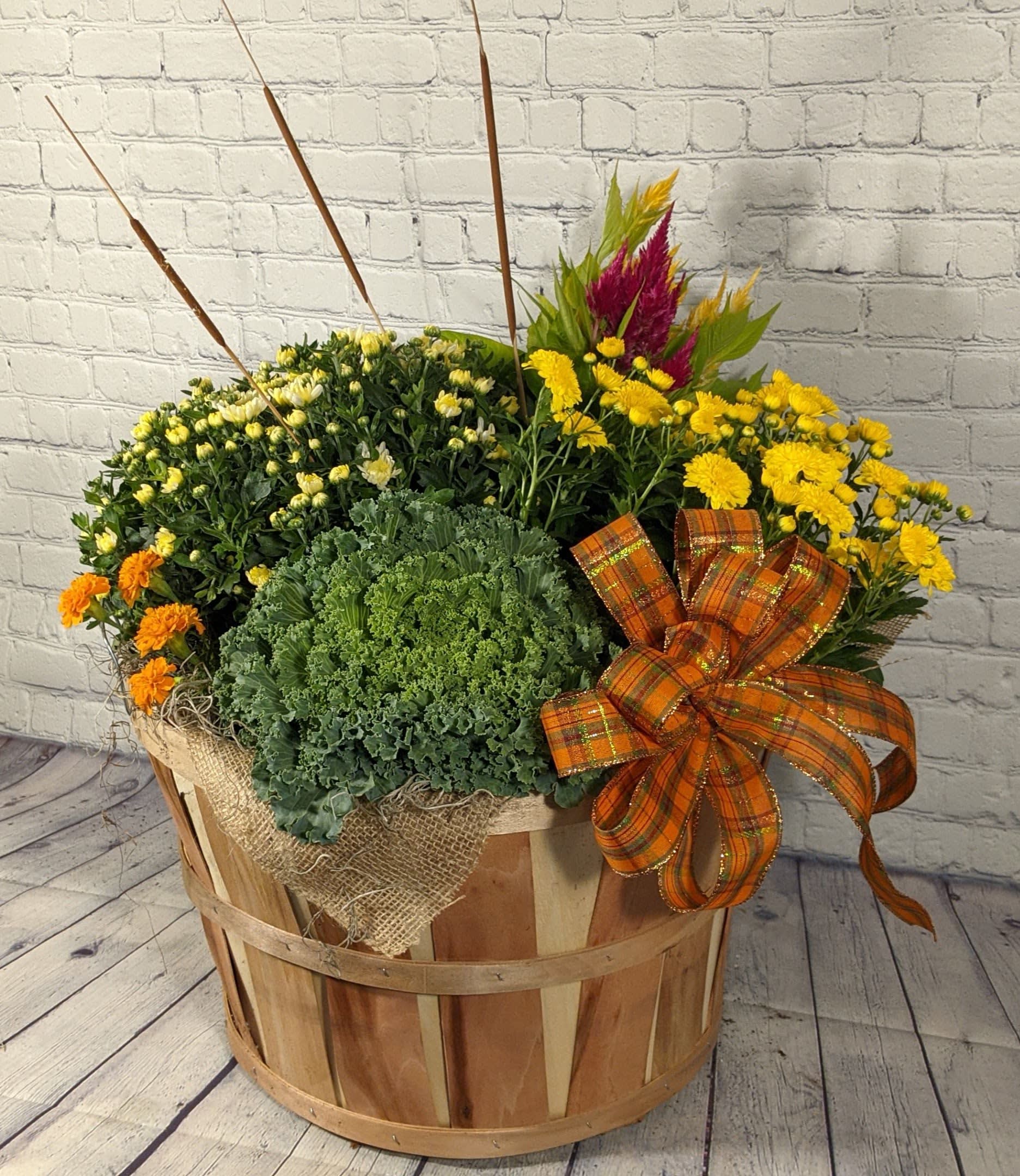 Fall flower arrangement in a wooden basket with yellow and orange blooms