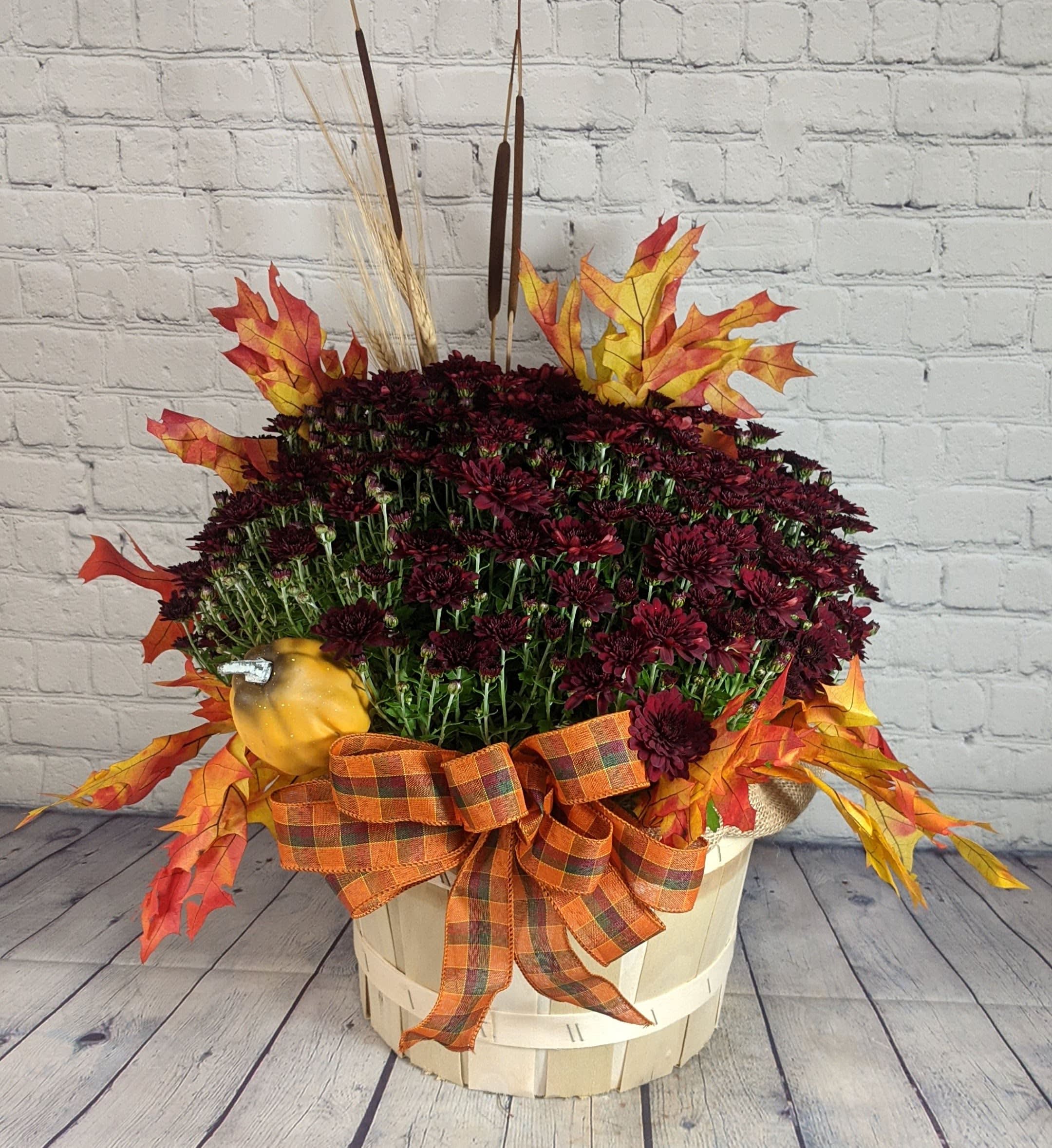 Fall flower basket with burgundy mums, faux leaves, and a plaid ribbon