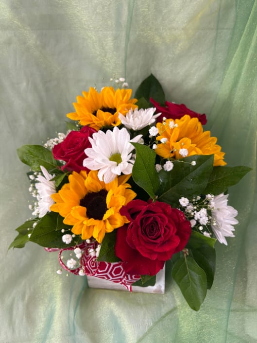 Bouquet of red roses, sunflowers, and white daisies in a gift box