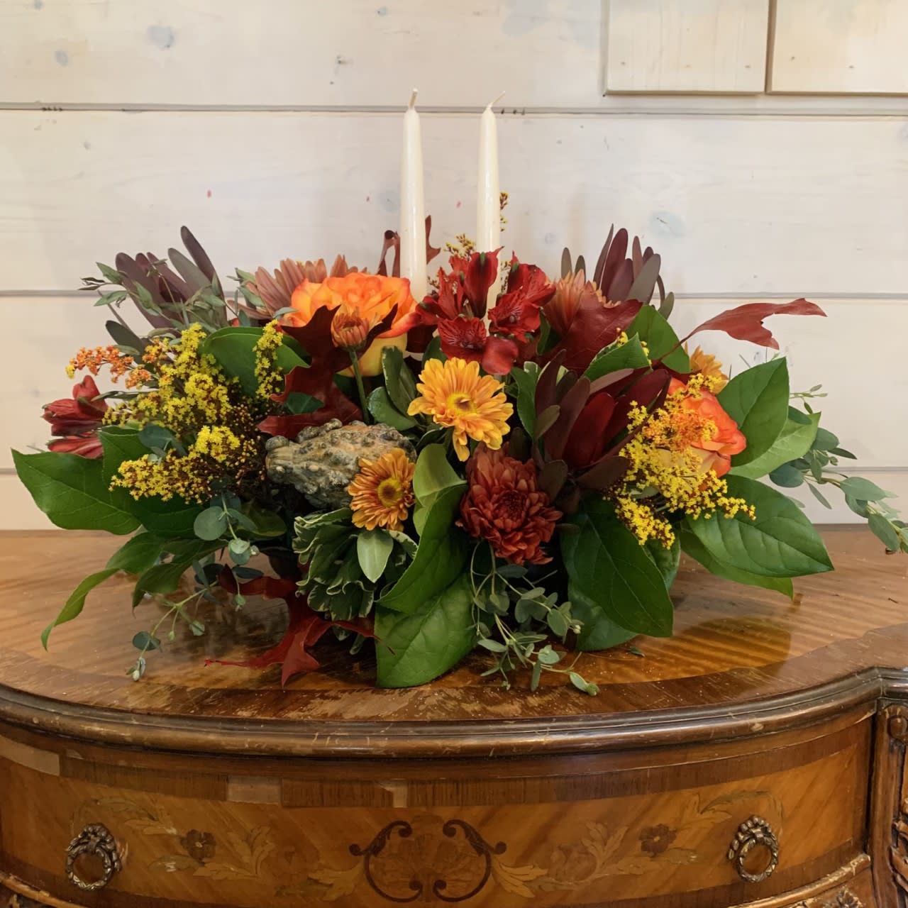 Autumn floral centerpiece with candles in a low arrangement