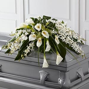 White floral casket spray with calla lilies and small white blossoms