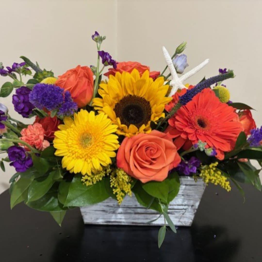 Colorful mixed bouquet in a rustic white wooden container