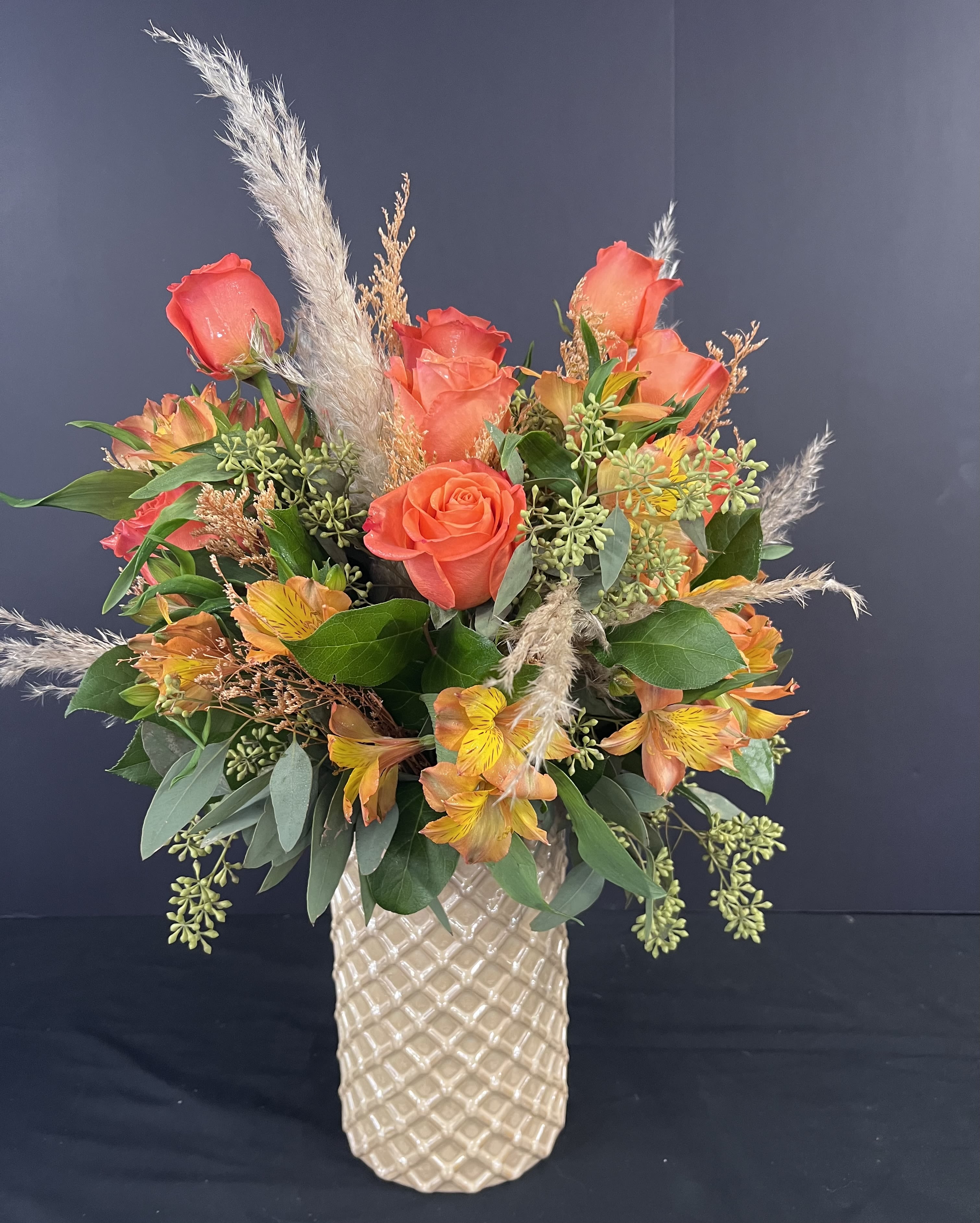 Orange rose and alstroemeria arrangement in a textured vase