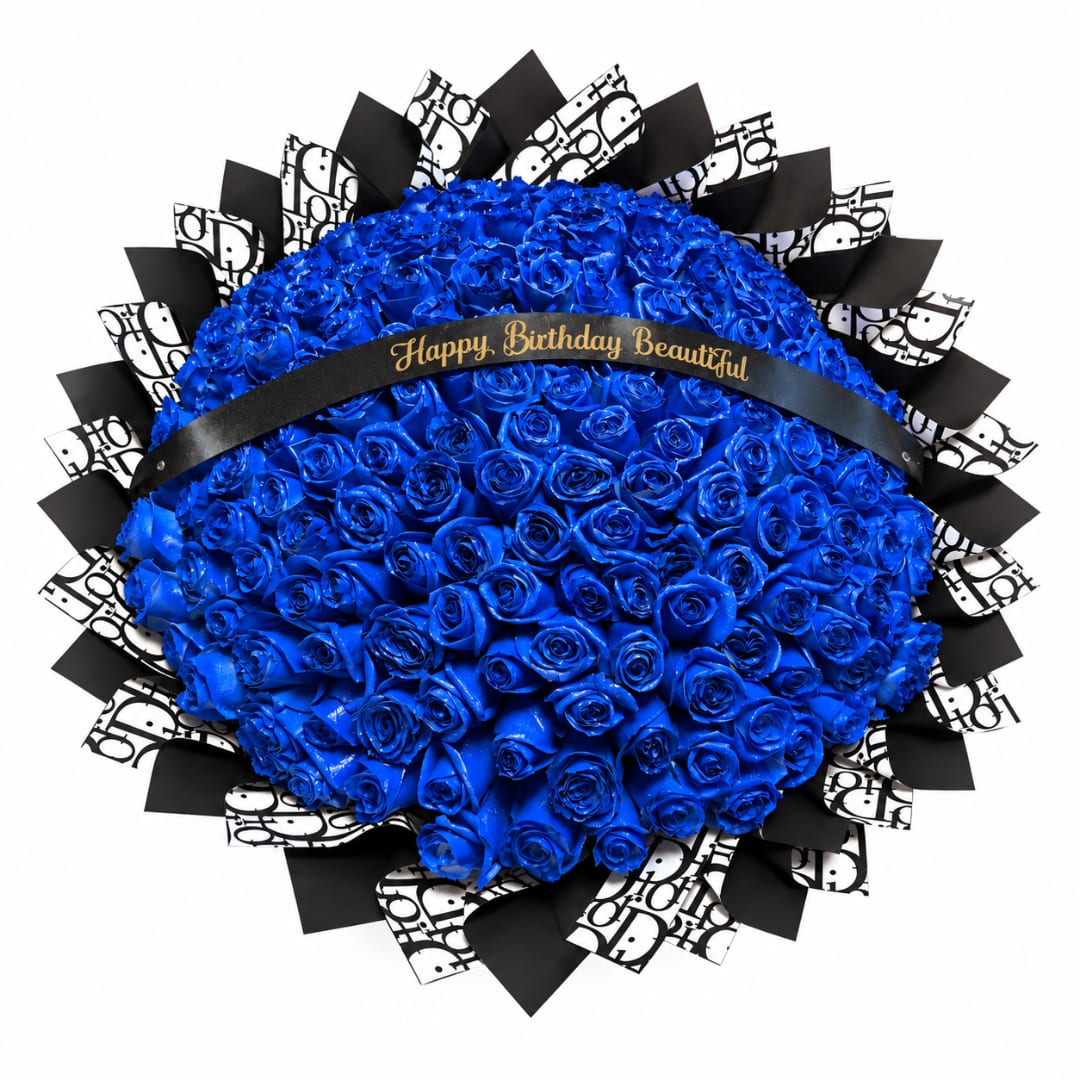 Blue rose bouquet with black-and-white patterned wrap and a birthday ribbon