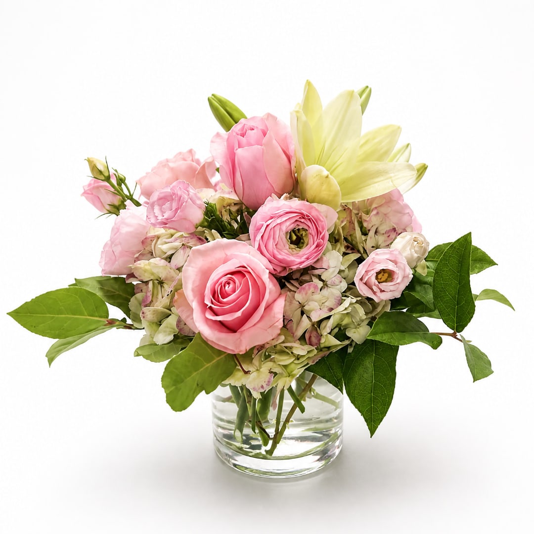 Pink roses and pale yellow lilies in a clear glass vase