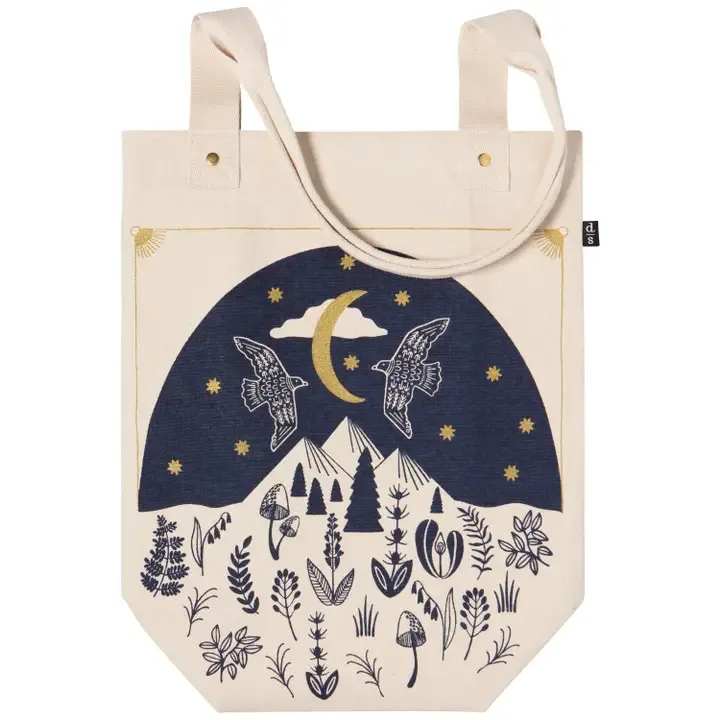 Moonlit Studio Tote - Lightweight yet sturdy, the slender Moonlit Studio tote features strong handles with reinforced hardware. Gaze up through a canopy of firs to see the night sky illuminated by the moon and twinkling stars with this design from Danica Studio. Dimensions: W13 x H16 x D6in / Strap Drop 12.5in  Material: 100% Cotton Care Instructions: Machine wash cold, gentle cycle. Hang to dry.