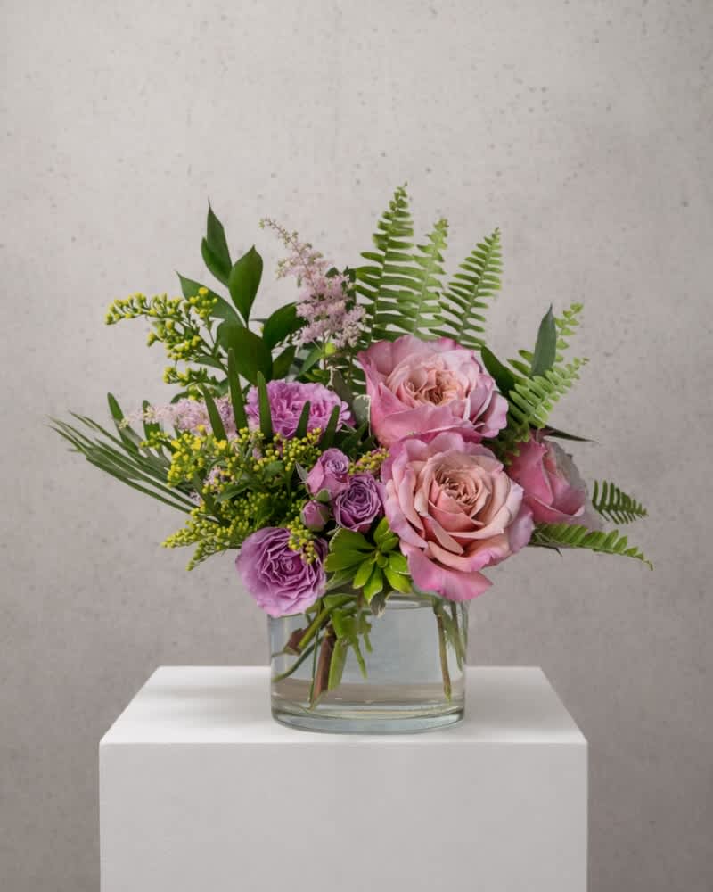 Pink and purple rose bouquet in a clear glass vase