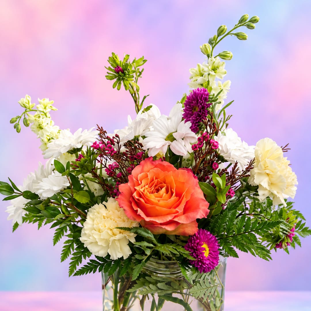 Mixed bouquet with orange rose, white daisies, and carnations in a glass vase