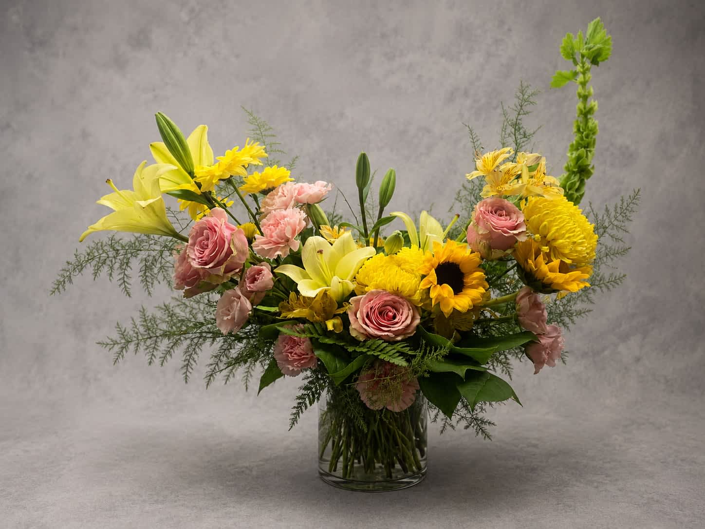 Golden Hour - Inspired by the warmth of a summer sunset, Golden Hour features cheerful sunflowers, soft pink roses, lilies, and seasonal blooms arranged in a lush garden style. Bright, joyful, and full of charm, this design is perfect for celebrating life's happiest moments.