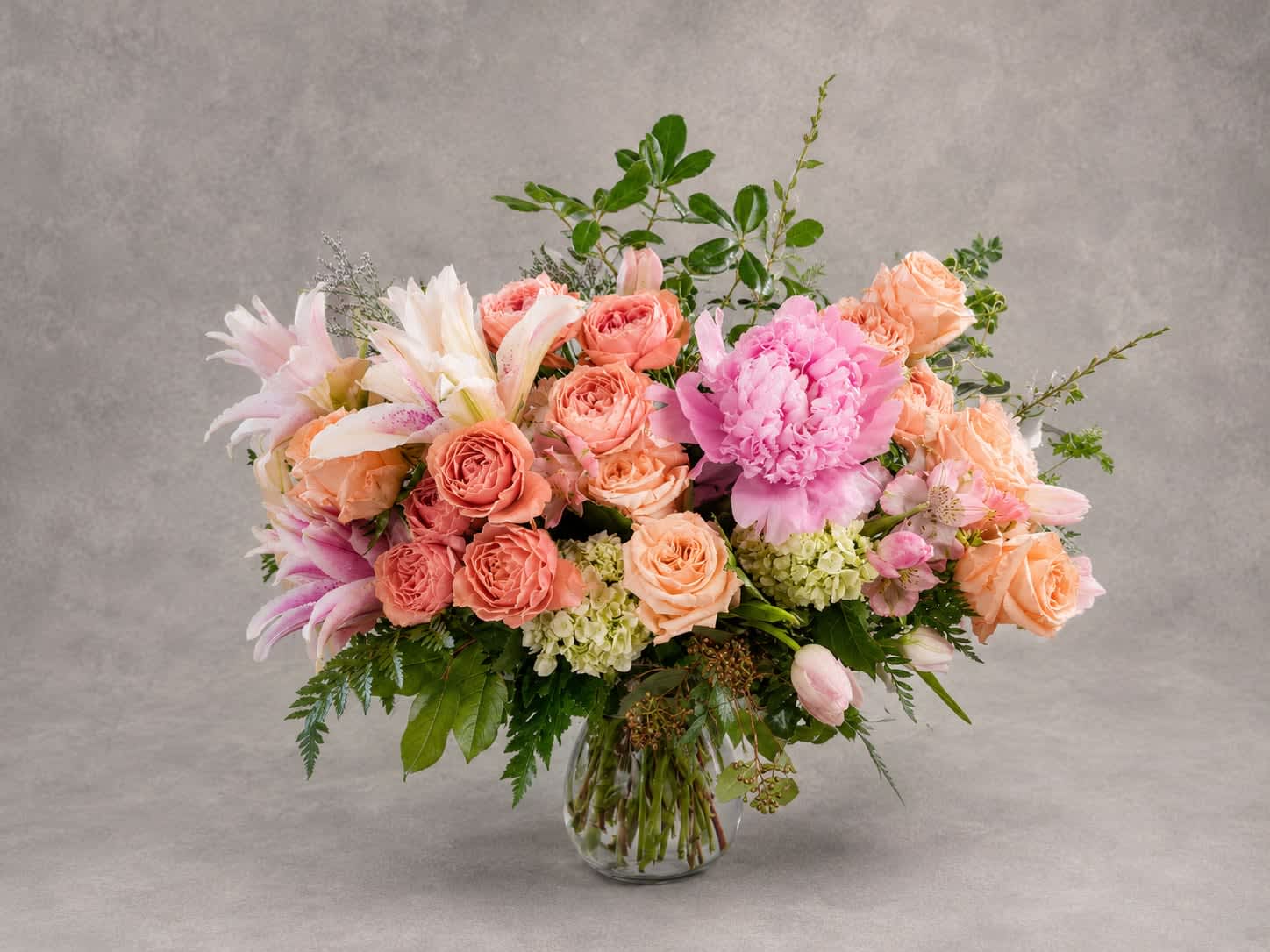 Mixed pink and peach bouquet in a clear glass vase
