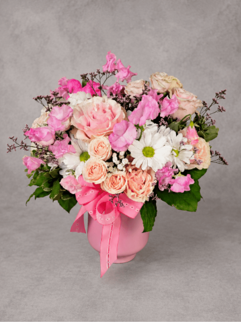 Pretty in Pink - Delicate shades of pink and blush come together in this charming arrangement featuring roses, spray roses, sweet peas, daisies, and seasonal accents. Designed in a keepsake pink container, Pretty in Pink is a sweet way to celebrate birthdays, new babies, friendships, and everyday moments.