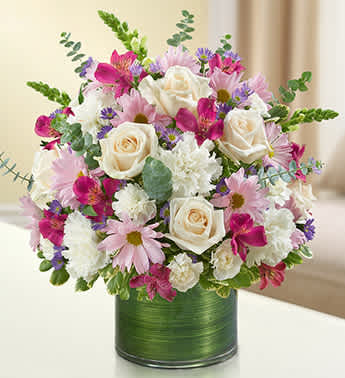 Cherished Memories - Lavender and White - Product ID: 95421   Remember a loved one with elegance and grace by sending our peaceful lavender and white arrangement in a classic cylinder vase. The freshest roses, snapdragons, alstroemeria, carnations and more are gathered by our florists to offer a tribute to a beautiful life. Graceful lavender and white arrangement of roses, snapdragons, alstroemeria, carnations, daisy poms, mini carnations and monte casino, gathered with variegated pittosporum and spiral eucalyptus Hand-designed by our expert florists in a stylish clear glass cylinder vase wrapped with a Ti leaf ribbon; vase measures 6"H Appropriate for the service or the home of friends and family members Large arrangement measures approximately 16"H x 17"L Medium arrangement measures approximately 15"H x 16"L Small arrangement measures approximately 14"H X 15"L Our florists hand-design each arrangement, so colors, varieties, and vase may vary due to local availability