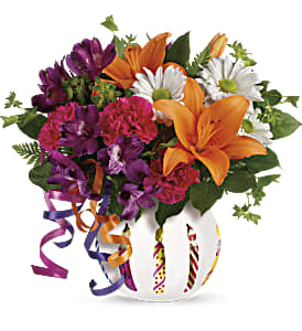 Colorful bouquet with lilies, daisies, and carnations in a decorated vase