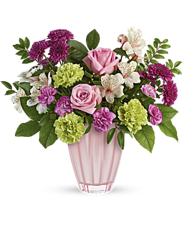 Sweet Serenade Bouquet - Surprise mom with the sweetest serenade! This touching rose bouquet, perfectly presented in a shimmering European glass keepsake vase, is sure to make her heart sing. This arrangement includes pink roses, light pink alstroemeria, green carnations, miniature pink carnations, purple cushion spray chrysanthemums, huckleberry and lemon leaf.  Product may be substituted due to availability  Orientation: All-Around Container may vary 