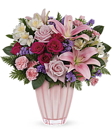 Pink and white mixed flower arrangement in a pink glass vase
