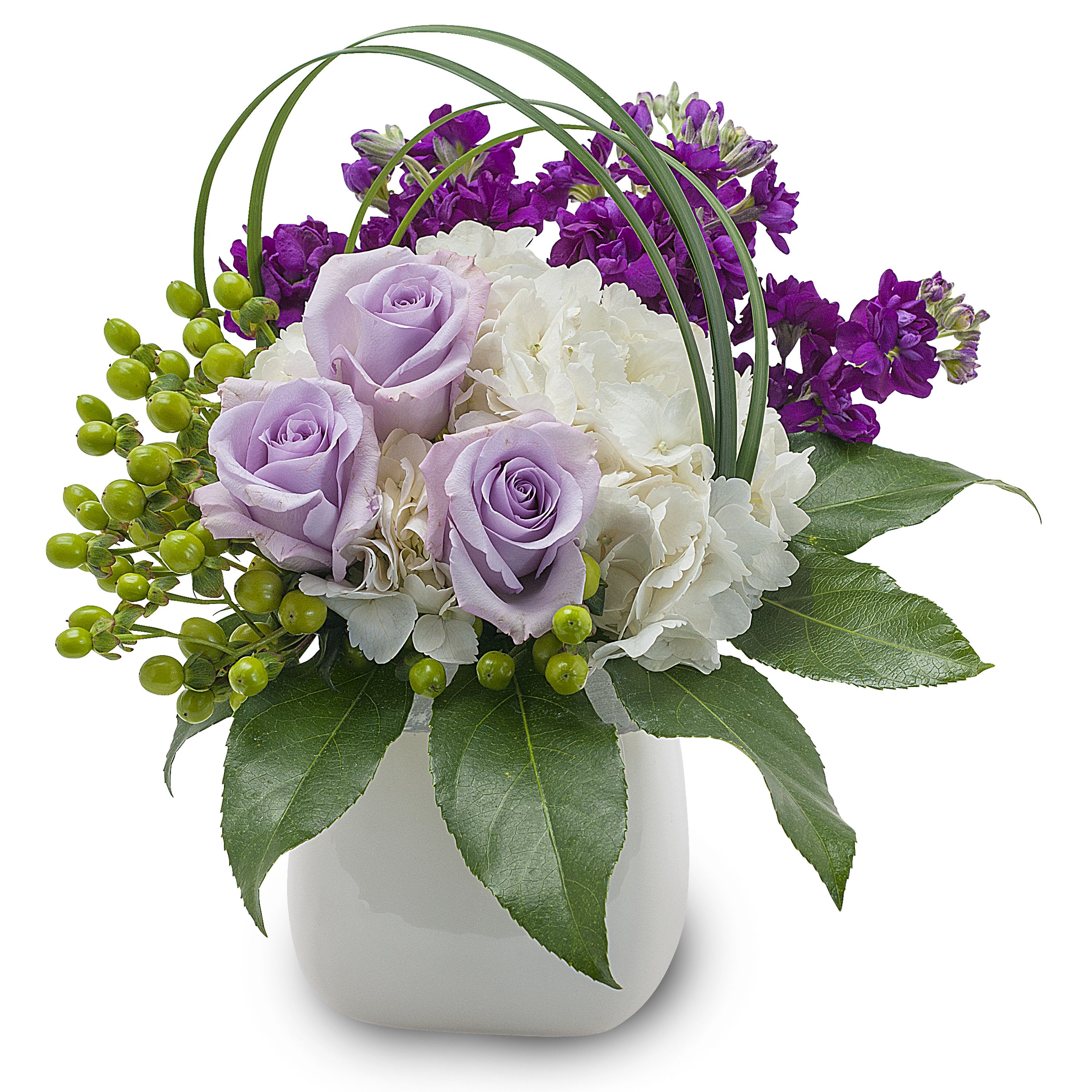 Her favorite color - Lovely lavender Roses and white Hydrangea, accented with purple stock and a bear grass loop. Approximately 7"W X 10"H