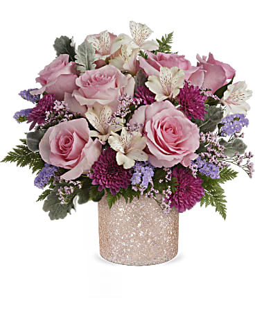 Pink roses and purple flowers arranged in a glittery vase