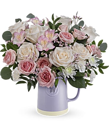 Blossom Delight - Gift Mom timeless elegance with our Sweetest Flutter pitcher. This food-safe ceramic pitcher is adorned with an embossed butterfly and a soothing lavender finish, making it the perfect complement to a vibrant Mother's Day bouquet. This FDA Sweetest Flutter pitcher, is perfectly paired with a bouquet of crème roses, pink spray roses, light pink alstroemeria, miniature white carnations, silver dollar eucalyptus, and huckleberry for an unforgettable Mother's Day gift. Orientation: All-Around Container may vary