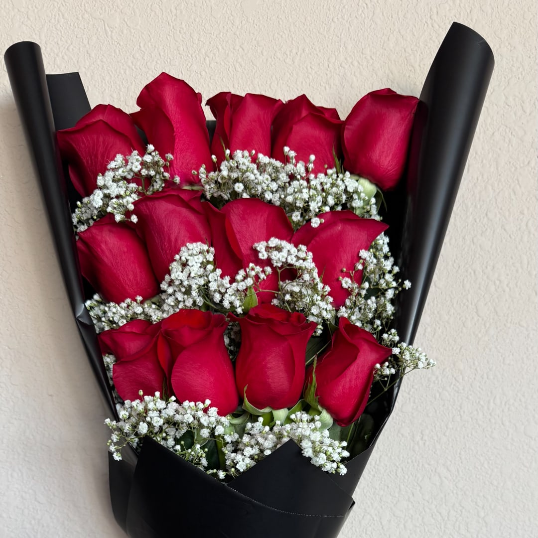 Bouquet of red roses with white baby's breath wrapped in black paper