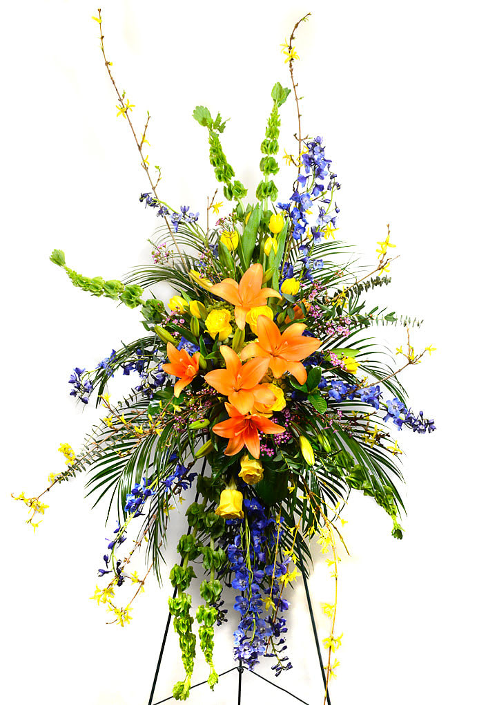 Tall floral spray with orange lilies and blue and yellow flowers