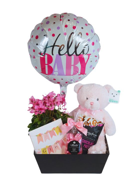 Baby gift basket with a balloon, teddy bear, flowers, and treats