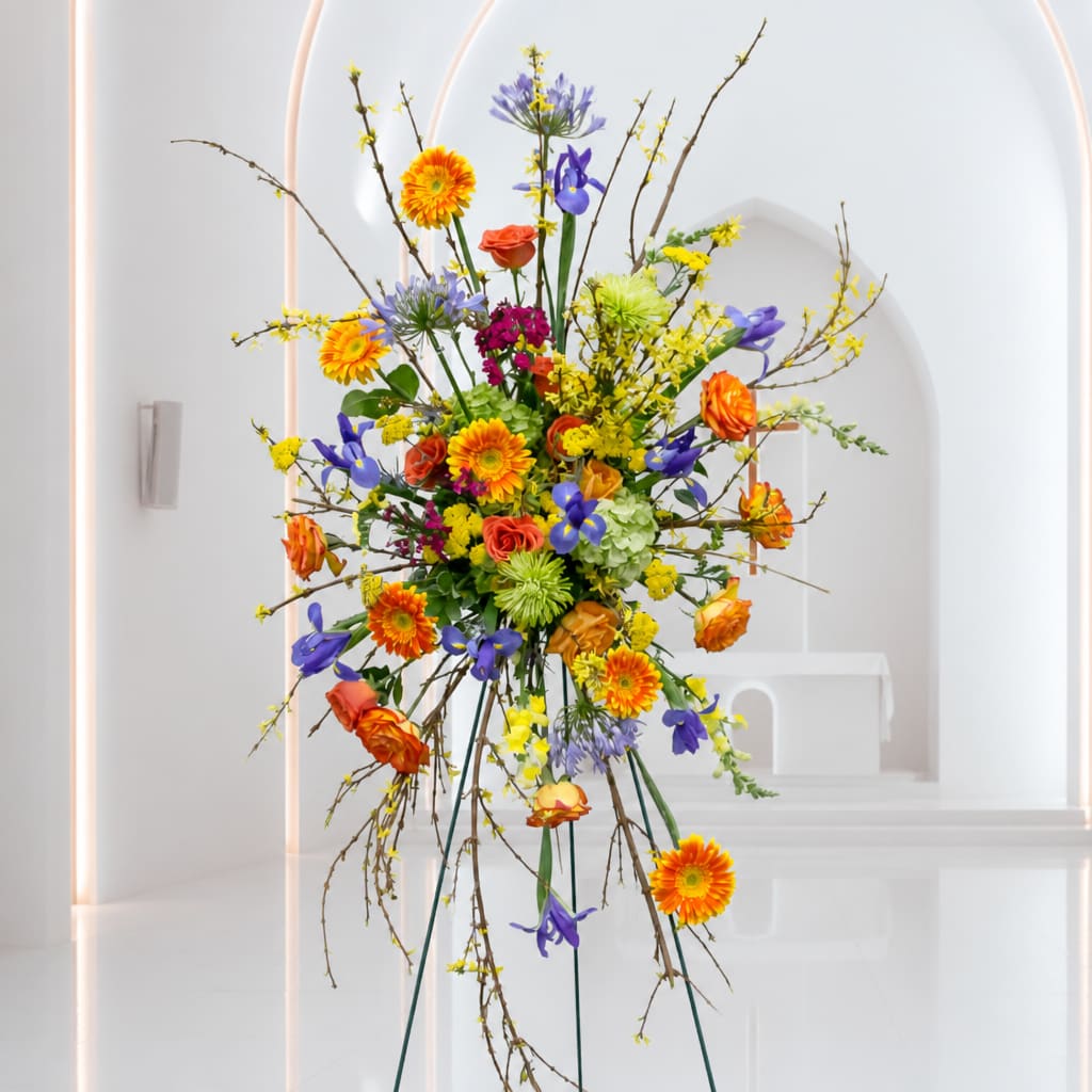 Tall mixed flower arrangement with orange, purple, yellow, and green blooms