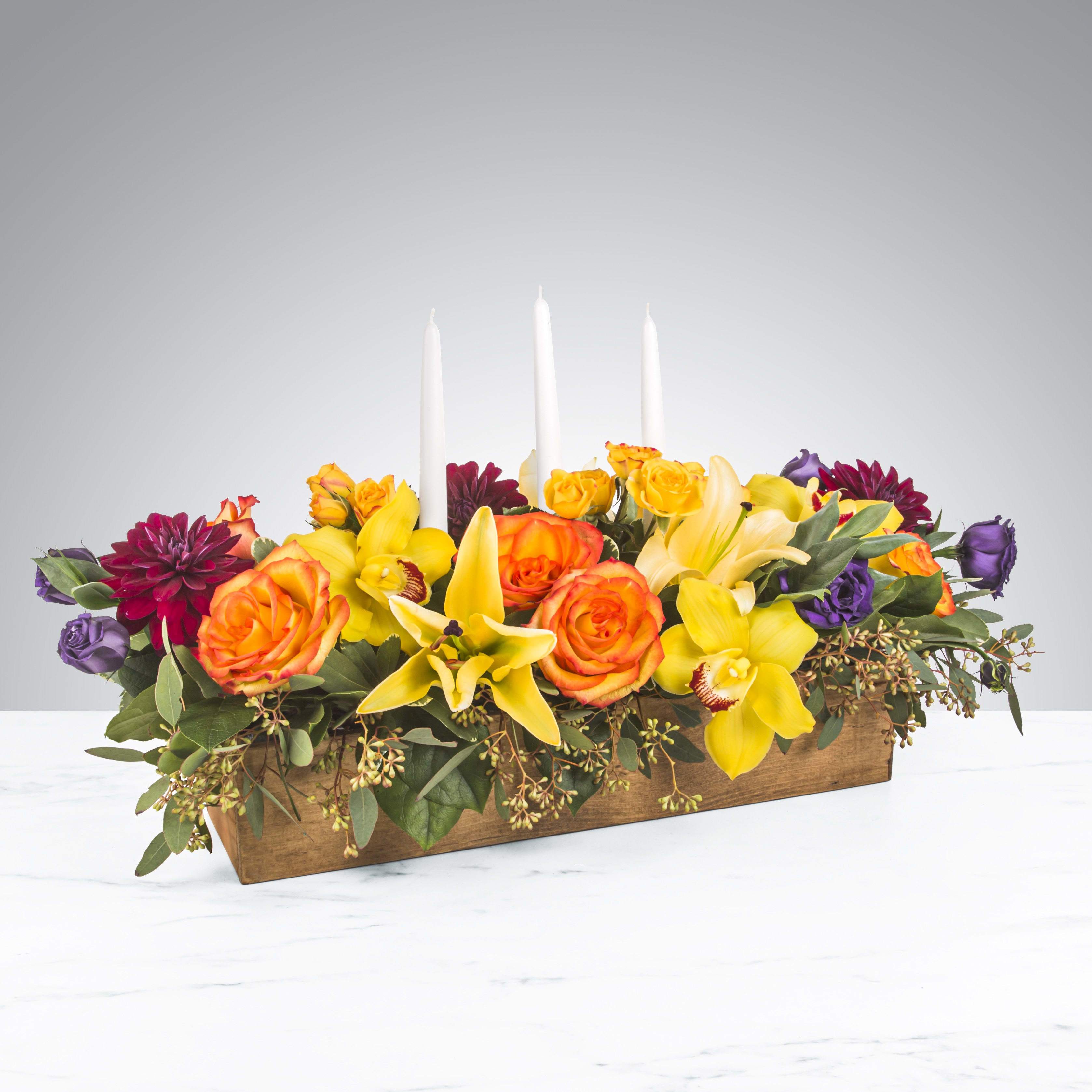 Full Harvest by BloomNation™ - No dinner party or food gathering is complete without a centerpiece and this large arrangement makes a big statement on any table. Featuring white dinner candles and a variety of flowers, dress up any event with this arrangement. Send it as a housewarming or thank you gift.   APPROXIMATE DIMENSIONS 25" W X 14" H