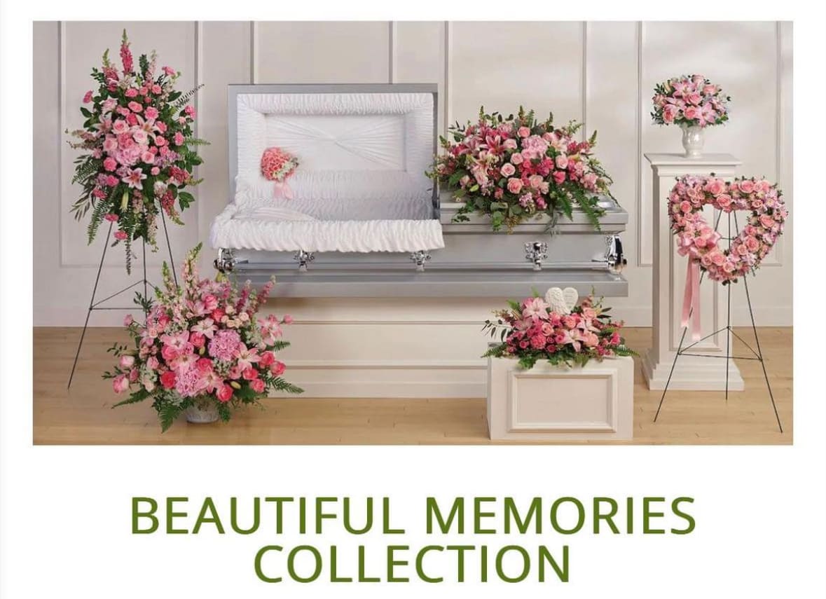 Pink floral funeral casket spray with matching standing wreaths and vase arrangements