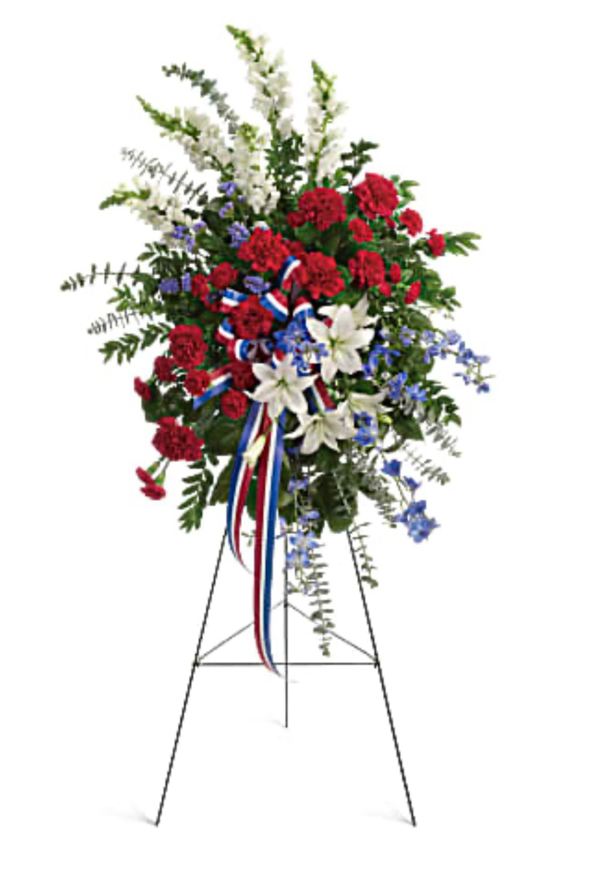 Standing floral spray with red, white, and blue flowers on an easel