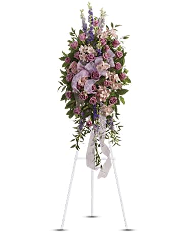 Standing floral spray with purple and pink flowers on an easel