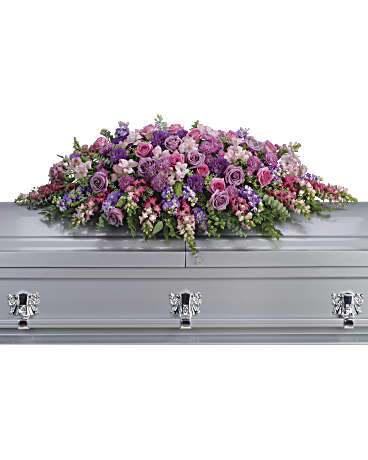 Lavender and pink floral casket spray on a silver casket