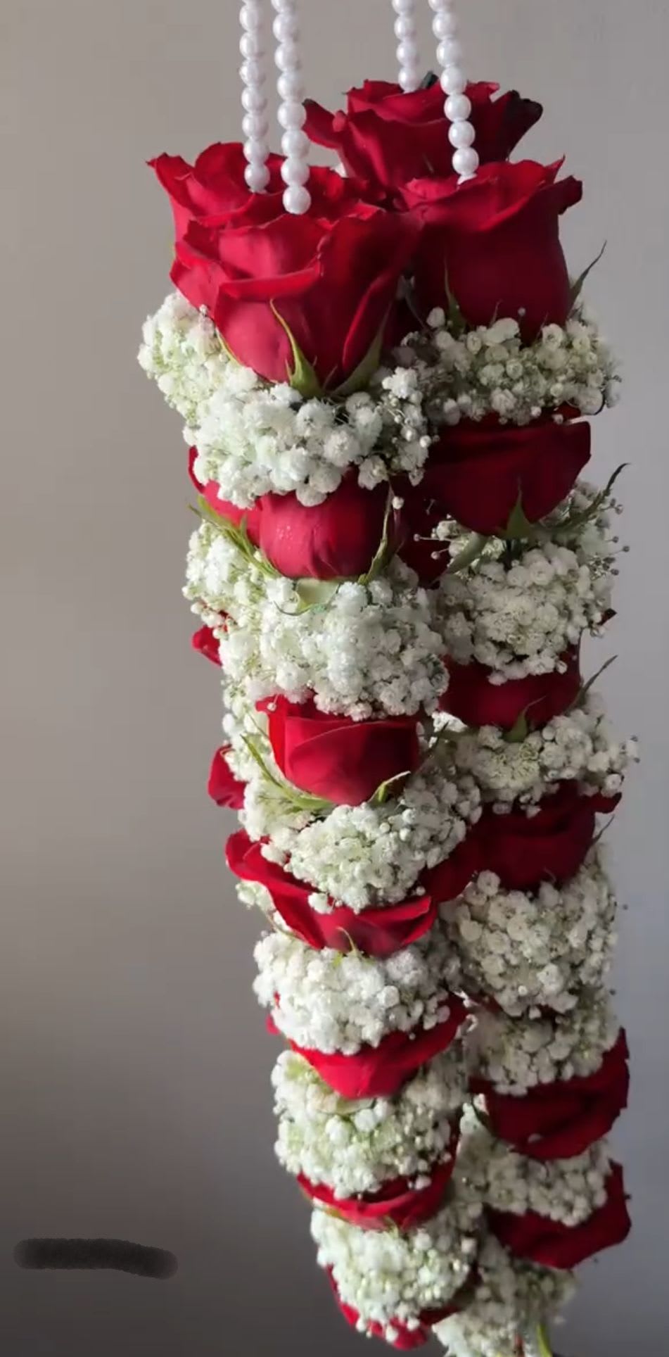 Hanging arrangement of red roses and white baby's breath