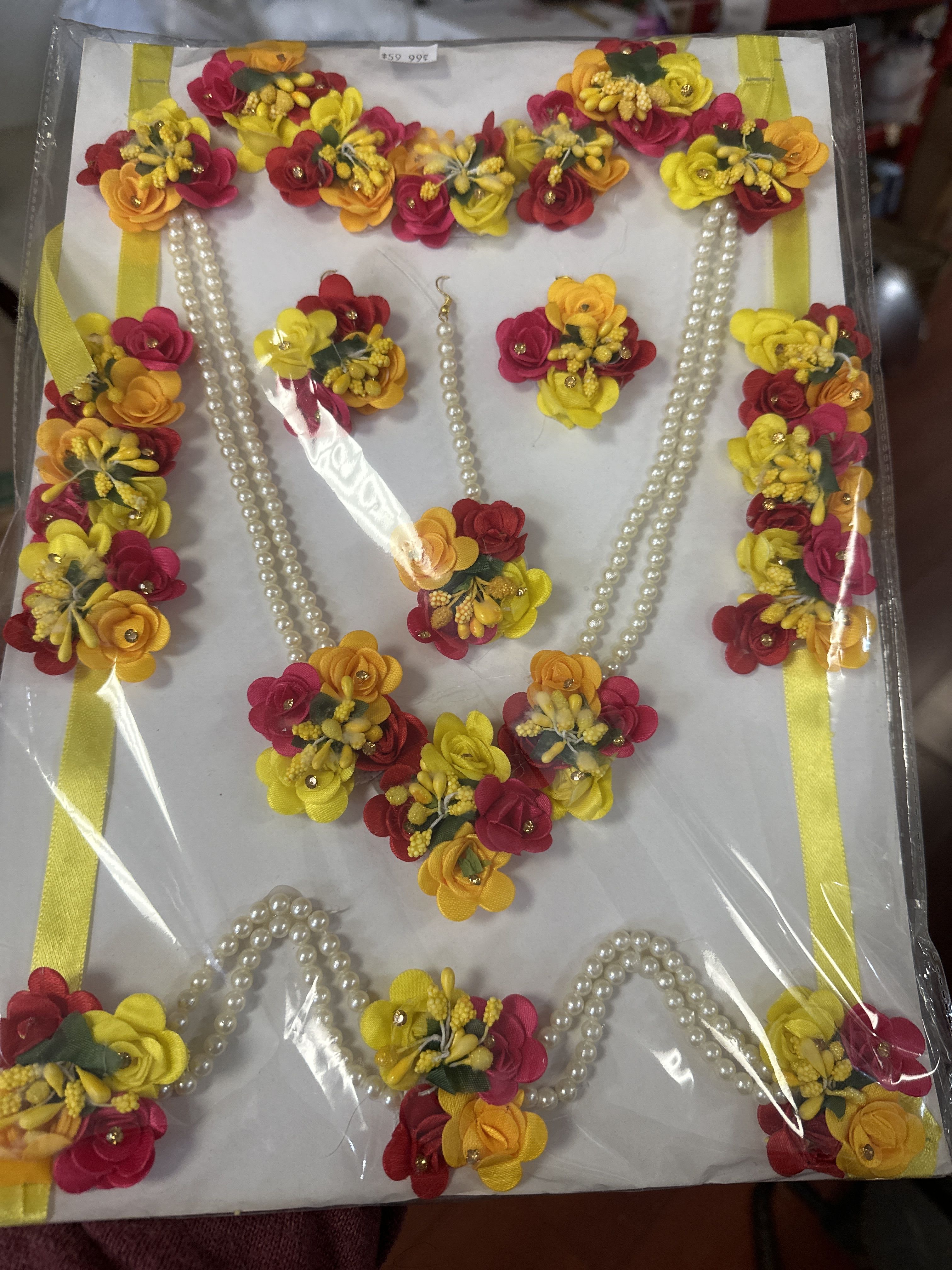 Decorative floral garland set with pink, yellow, and orange blossoms and pearl strands