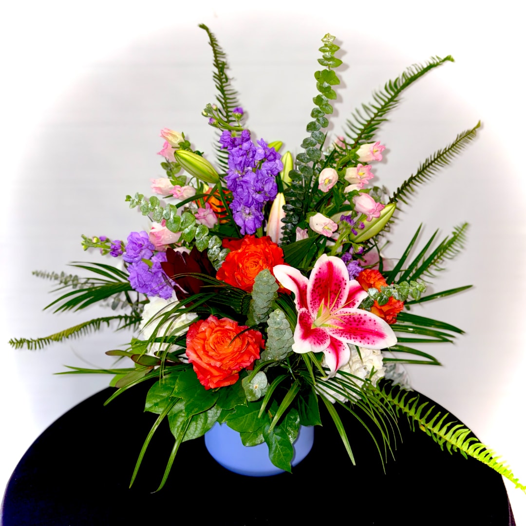 Colorful mixed flower arrangement in a blue vase