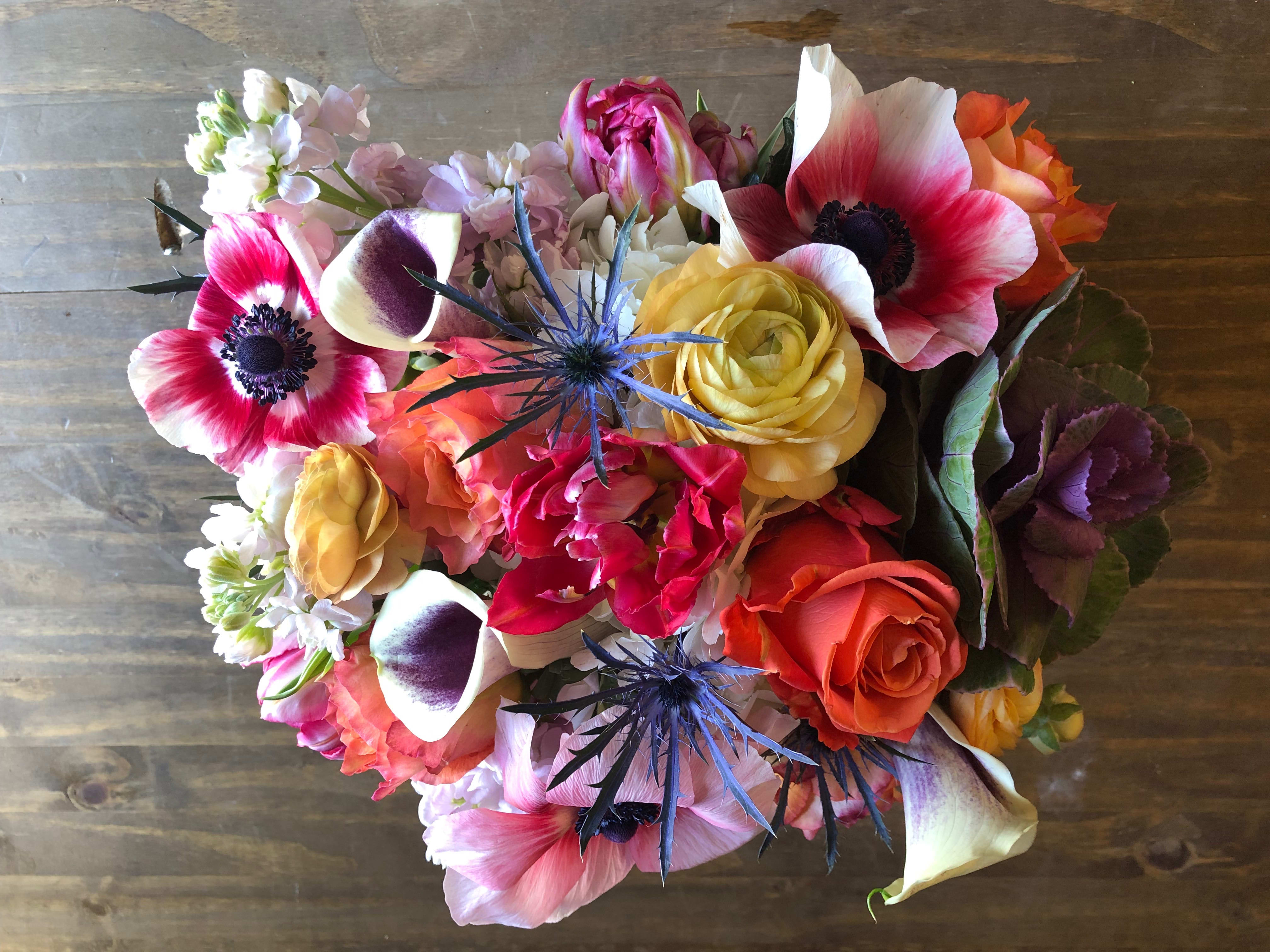 Mixed bouquet with pink anemones, roses, calla lilies, and blue thistle