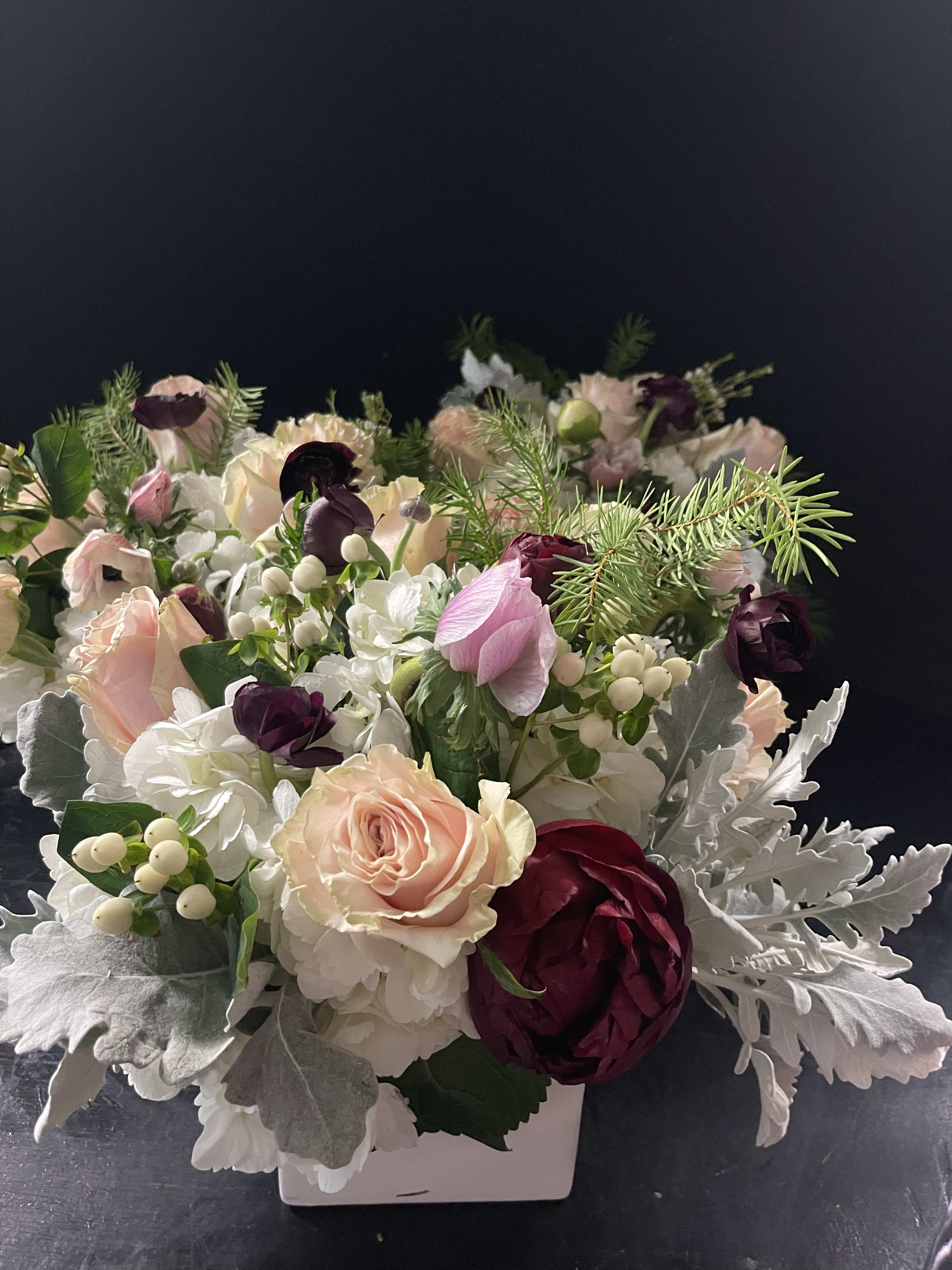 Compact floral arrangement with pink, white, and burgundy blooms in a white container